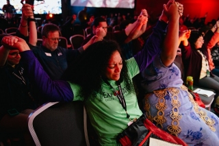 Attendees clasp hands together showing support for each other on this journey with God.