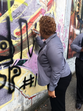 Rev. Kenya Lovell, Bethune-Cookman University, writes on peace wall in Belfast. 