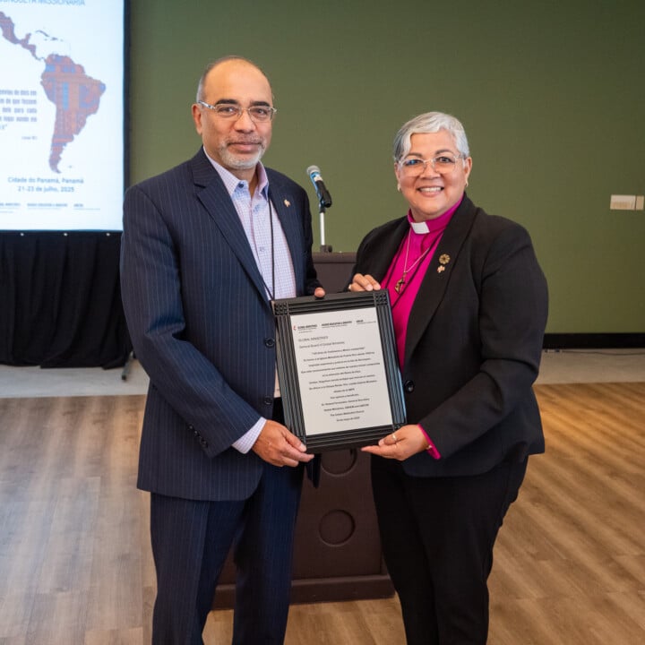 General Secretary Roland Fernandes (left) holds a plaque presented to Bishop Dr. Lizzette Gabriel Montalvo, president of the Council of Bishops of CIEMAL and Bishop of the Methodist Church of Puerto Rico, celebrating 125 years of Methodist mission in Puerto Rico. Photo by Adam Bowers