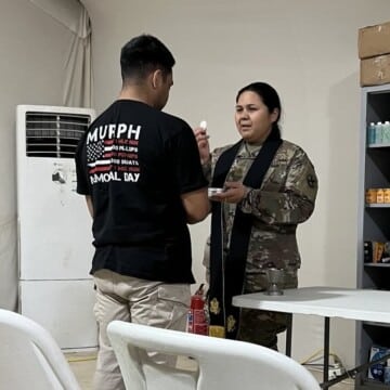 Chaplain (Major) Amor Del Rosario serves communion to a soldier. Sometimes there is not a dedicated chapel building and we have to create a holy space with what we have. (Photo courtesy of Amor Del Rosario)