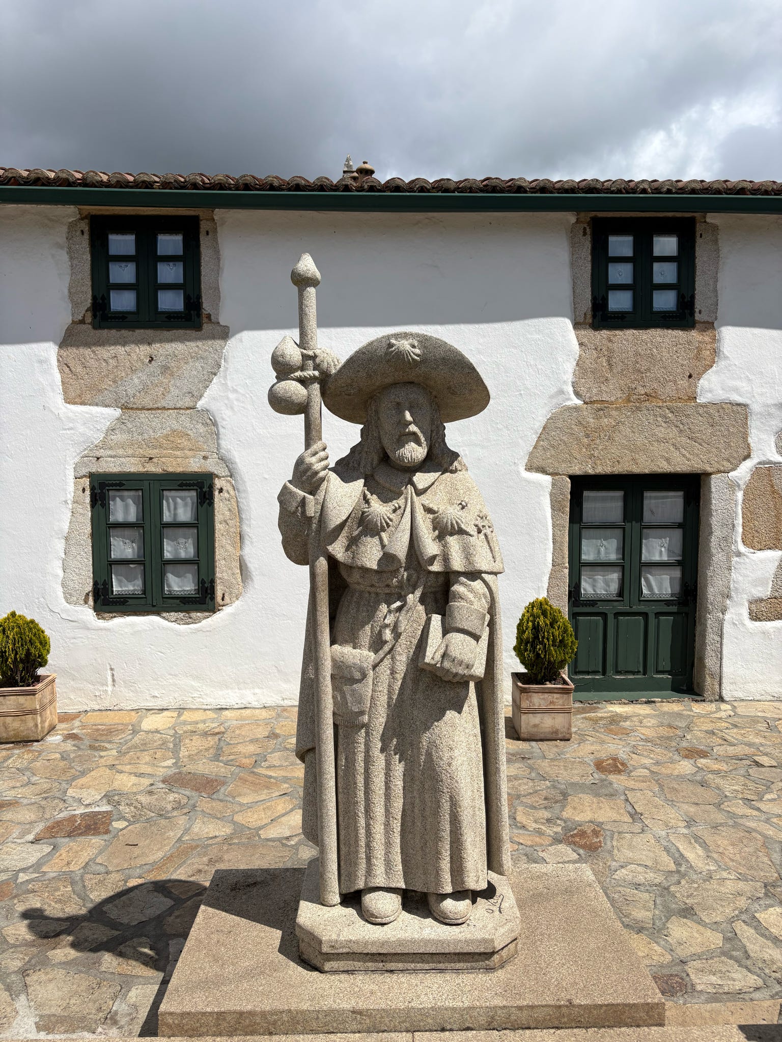 84d4f32d-e8ce-4469-8cdd-2c4643c9e389 (1) A statue of St. James the Apostle stands with a traditional pilgrim's walking stick along El Camino. Walking sticks are among the most ubiquitous tools carried by pilgrims today, echoing centuries-old depictions of St. James as a traveler on the sacred route to Santiago de Compostela. Photo Courtesy of the Rev. Kris Mares